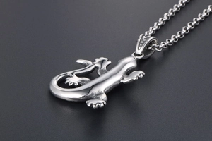 Gros plan détaillé du pendentif lézard en acier inoxydable poli avec finition vintage