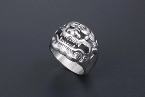 Close-up of vintage titanium steel ring featuring detailed Chinese Kylin mythical beast carving