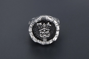 Detailed view of silver skull ring with biker chain border made of stainless steel
