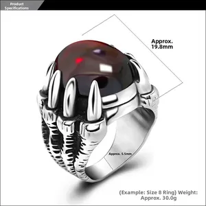 Détail macro d'une bague griffe de dragon gothique avec une grande pierre rouge