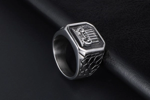 Detail of silver signet ring with hexagonal crown relief and industrial crackle texture