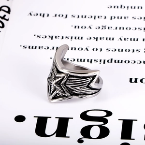 Detailed close-up of retro punk star ring with embossed feather texture on steel band