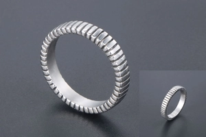 Macro detail of vertical ribbed texture on a silver titanium steel unisex band ring