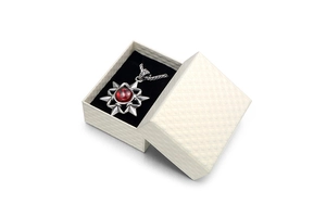Vintage starburst pendant necklace with a red gemstone and a luxury textured jewelry gift box
