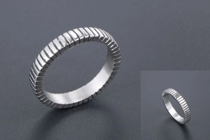 Macro shot of silver titanium steel ring featuring vertical textured grooves and polished finish
