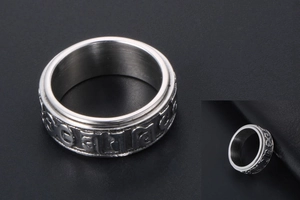 Macro shot of rotatable stainless steel ring with engraved Six-Word Mantra symbols
