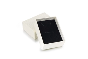 Detailed view of white jewelry gift box with textured diamond pattern and black sponge lining