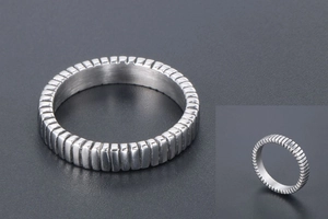 Macro detail of titanium steel ring with industrial vertical prism textured pattern