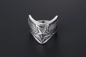 Macro detail of vintage titanium steel wide ring featuring a 3D star and wing textures