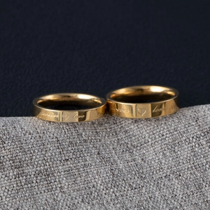 Detail of couple rings in gold finish engraved with Forever Love on fabric surface