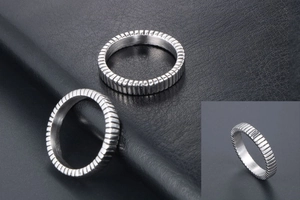 Detailed view of titanium steel rings with textured vertical grid pattern on dark leather