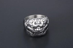 Macro shot of vintage titanium steel ring featuring detailed mythical beast carving