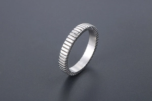 Detailed view of titanium steel ring featuring vertical textured patterns and polished finish
