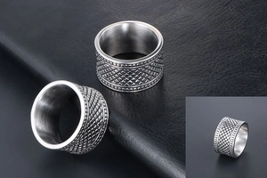 Détail de la bague large pour homme en acier titane avec motif damier et bords perlés