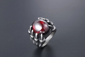 Vue détaillée d'une bague griffe de dragon argentée avec une grande pierre rouge ovale