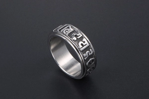 Close-up of rotatable stainless steel ring featuring engraved Buddhist mantra symbols