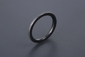 Close-up of black matte titanium ring with stardust finish and polished inner surface