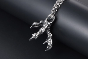Macro shot of vintage silver punk dragon claw pendant on a dense rolo chain necklace