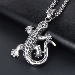 Pendentif lézard détaillé en acier inoxydable sur fond de cuir noir texturé