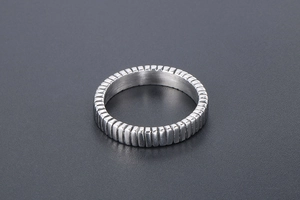 Macro shot of titanium steel ring featuring dense vertical textured grooves and matte finish
