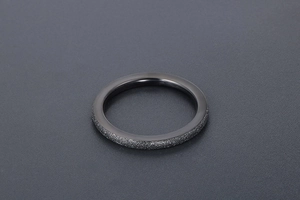 Detail of minimalist black matte titanium ring with sandblasted finish and smooth inner surface