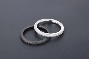 Close-up of matte and polished stainless steel rings in silver and black finish