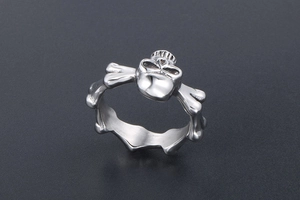 Close-up of punk style titanium steel ring featuring silver skull and bone link details