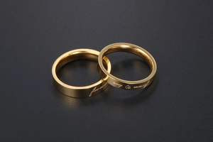 Detailed view of gold couple rings with forever love engraving and heart motif