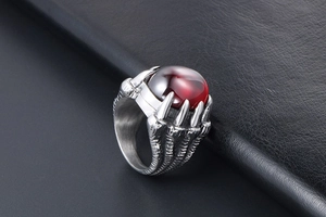 Détail de bague griffe de dragon vintage avec pierre rouge et écailles ciselées