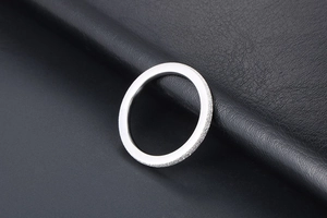 Macro shot of matte silver titanium steel ring with polished inner surface on leather