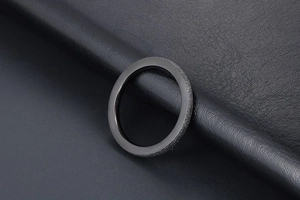 Macro detail of black frosted titanium steel ring with smooth inner surface finish