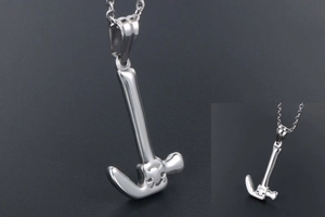 Macro shot of silver hammer pendant with cat face carving on a sleek steel chain