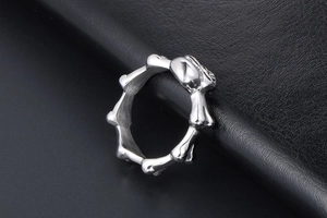 Macro shot of a punk skull bone joint ring in silver finish on black leather texture