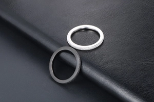 Close-up of frosted silver and black couple rings with starlight texture finish