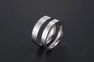 Close-up of polished stainless steel couple rings with Forever Love engraving