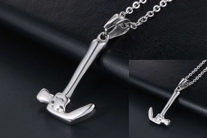 Macro detail of silver hammer-shaped pendant in polished titanium steel on black leather