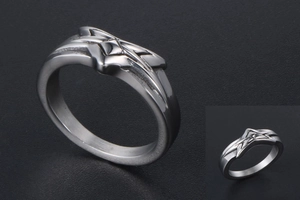 Macro detail of silver star-shaped relief on a minimalist stainless steel ring for men and women