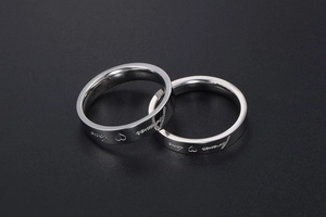 Detail of interlocking silver titanium steel rings with forever love engraving