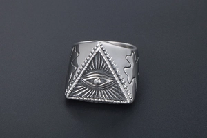 Macro shot of punk evil eye totem and cross carvings on a vintage silver steel ring