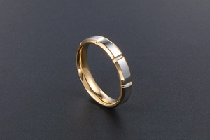 Vue détaillée de la bague bicolore or et argent rainurée sur fond noir texturé