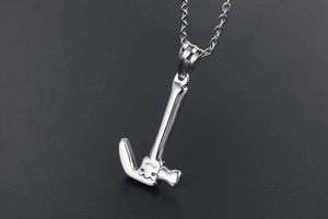 Close-up of polished stainless steel claw hammer pendant with metallic finish