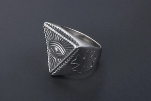 Close-up of vintage punk steel ring with triangle evil eye symbol and side cross detail
