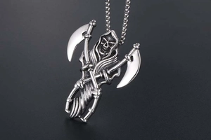 Detailed macro view of a grim reaper skull pendant with dual scythes in stainless steel