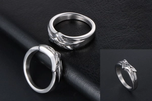Detail of silver titanium steel rings featuring eagle wing embossed patterns on black leather