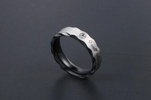 Detail of gray titanium steel ring with wave cut, small diamond and I will always engraving
