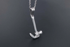 Macro shot of silver mini hammer pendant with cat face engraving on O-chain necklace