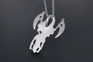 Macro detail of polished steel grim reaper pendant with scythes on beaded chain necklace