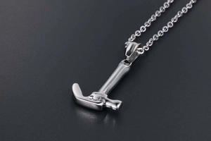 Macro shot of silver hammer pendant necklace with polished finish and detailed industrial tool design