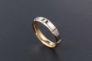 Détail d'une bague bicolore en acier inoxydable or et argent avec rainures verticales