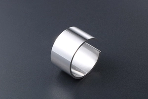 Macro view of wide silver open ring with polished mirror finish on a matte grey surface